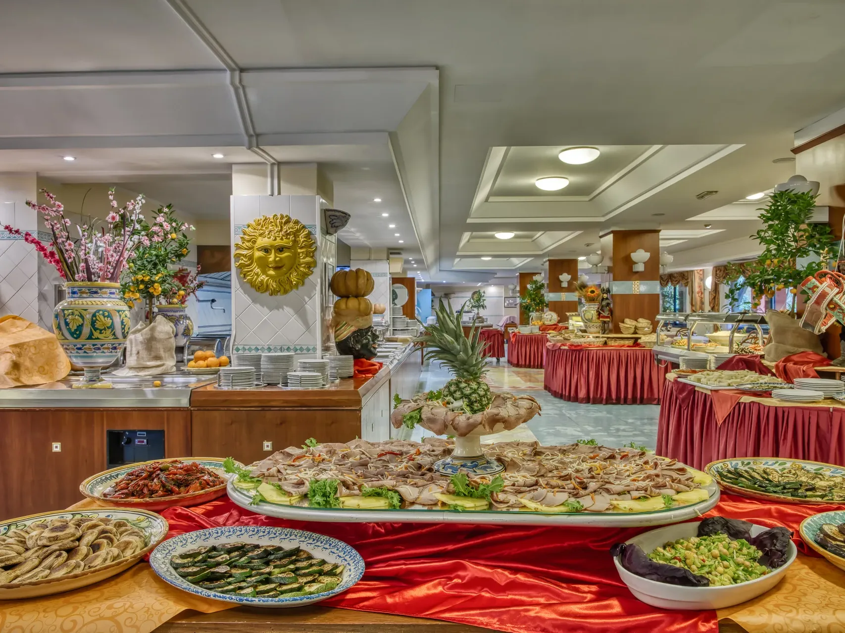 Buffet ricco di piatti tipici siciliani con decorazioni in ceramica e sole dorato