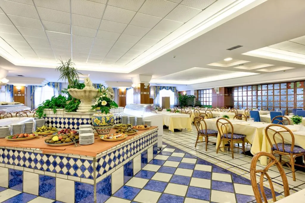 Sala ristorante interna con buffet, fontana decorativa e pavimento a scacchi