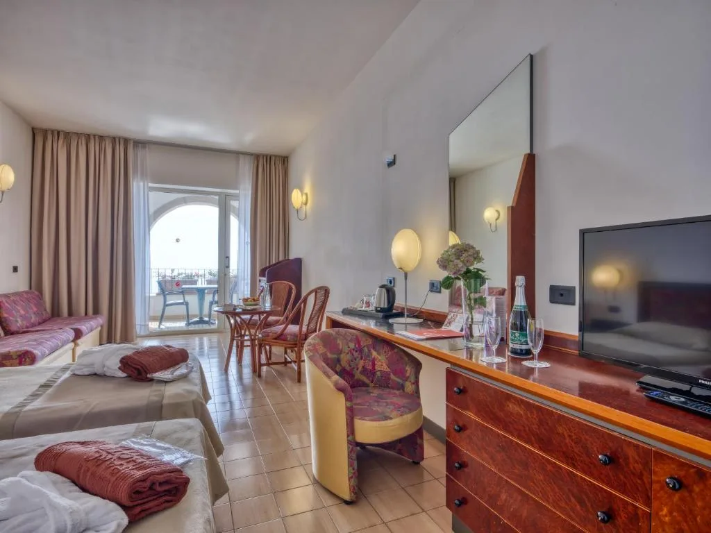 Camera con letto, scrivania, TV e balcone con vista