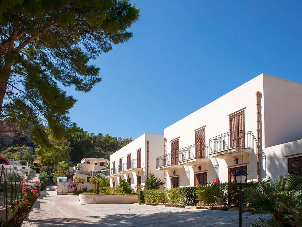 Edifici bianchi del resort con balconi lungo un vialetto