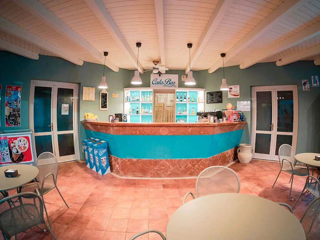 Cala Bar interno con bancone e tavolini in stile mediterraneo