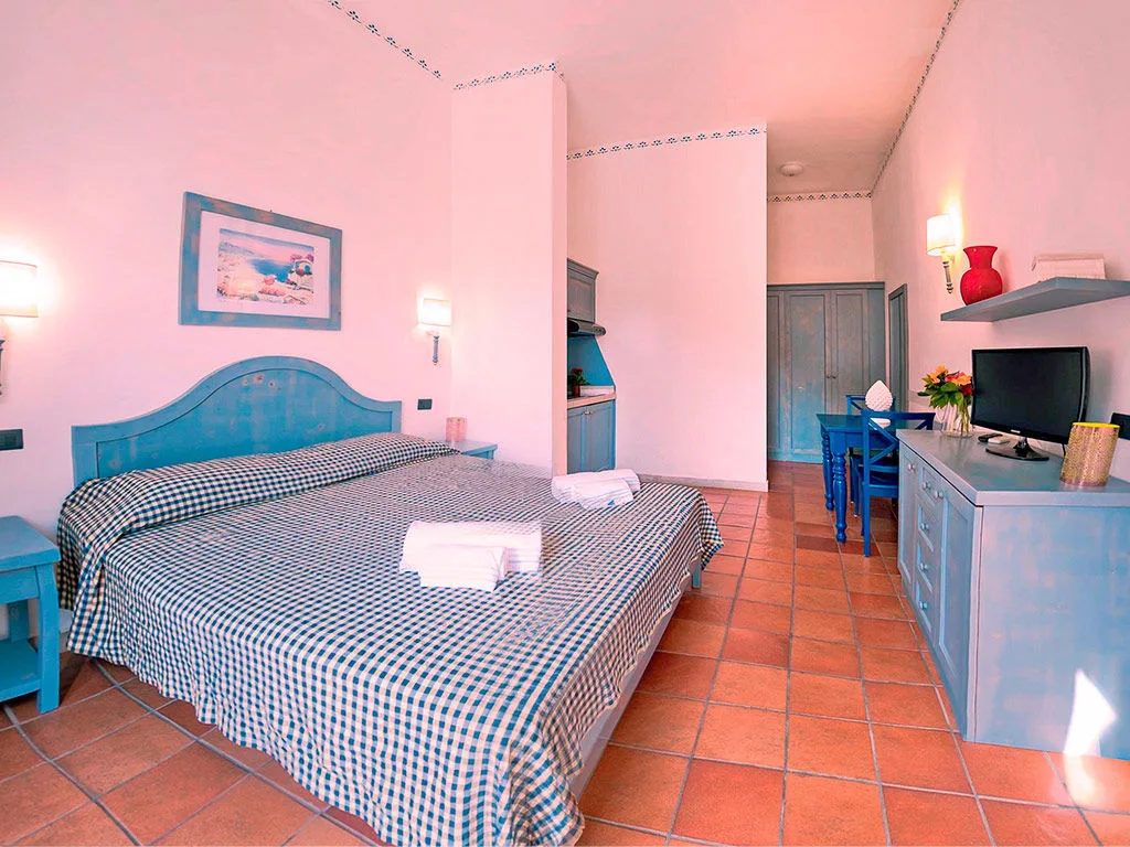 Monolocale con letto matrimoniale e angolo cucina in cotto