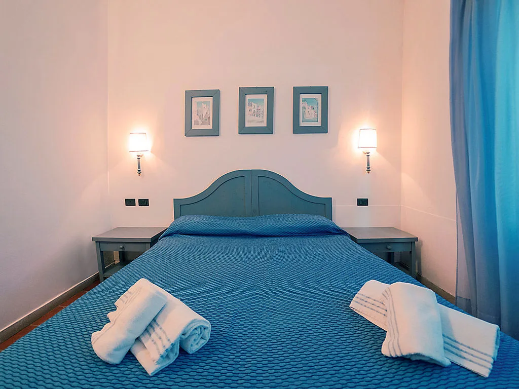 Camera da letto matrimoniale con copriletto blu e quadri alla parete