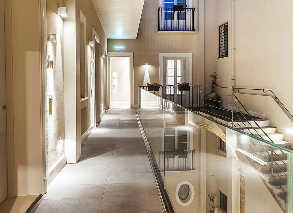Corridoio interno illuminato con ringhiera in vetro affacciato sul cortile