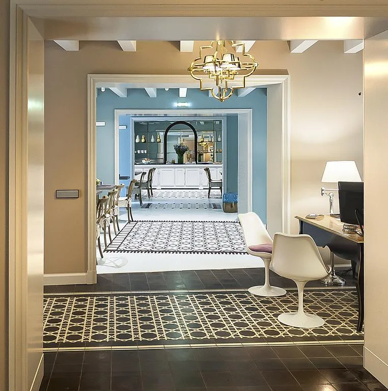 Sala interna con pareti azzurre, lampadario dorato e pavimenti a mosaico decorati
