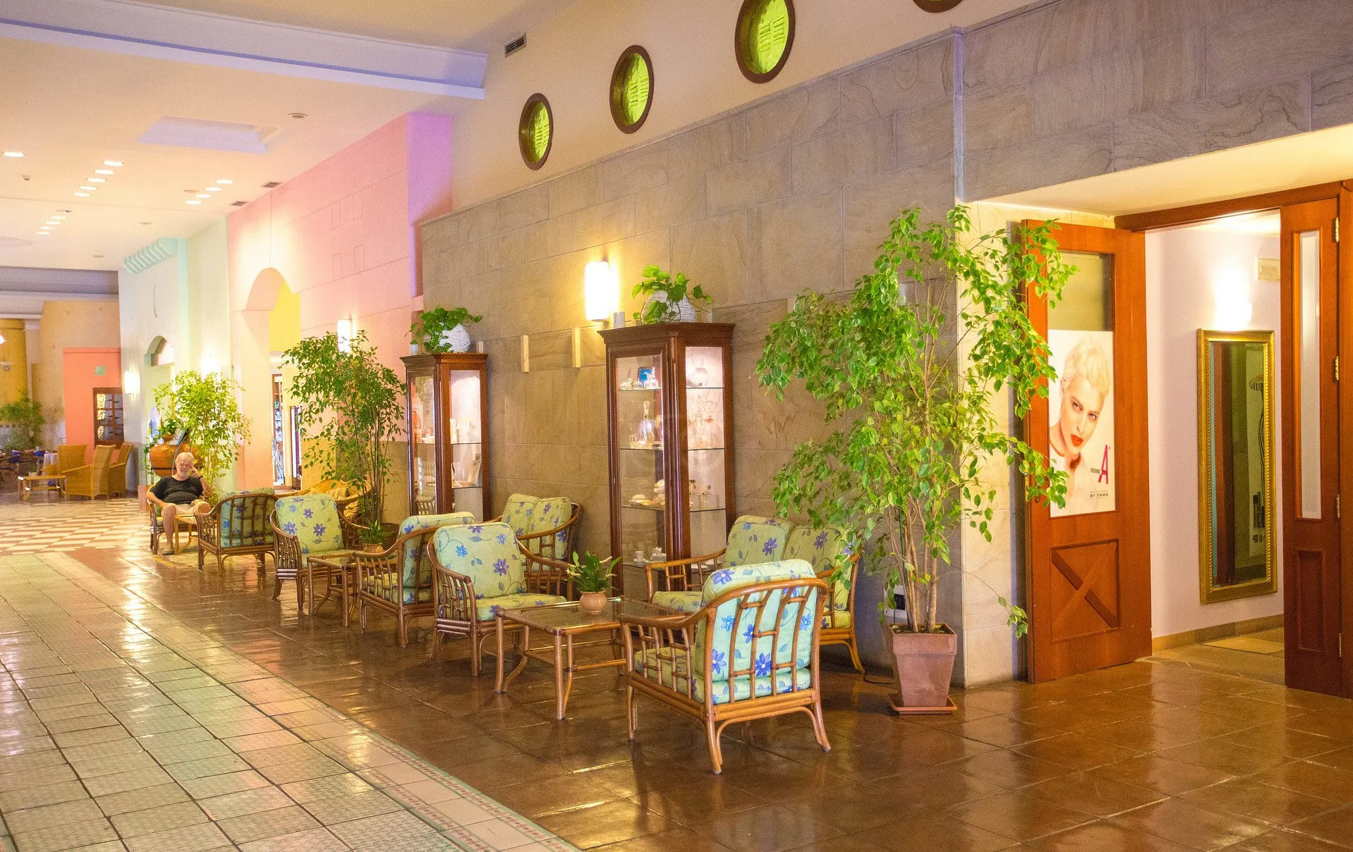 Area lounge dell'hotel con poltrone in rattan e piante verdi