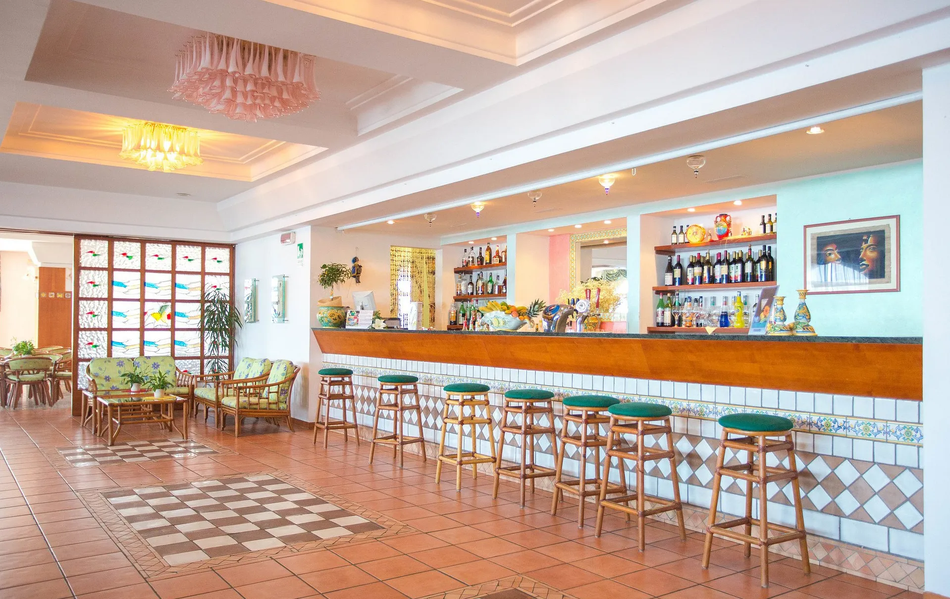 Bar interno dell'hotel con bancone in legno e sgabelli