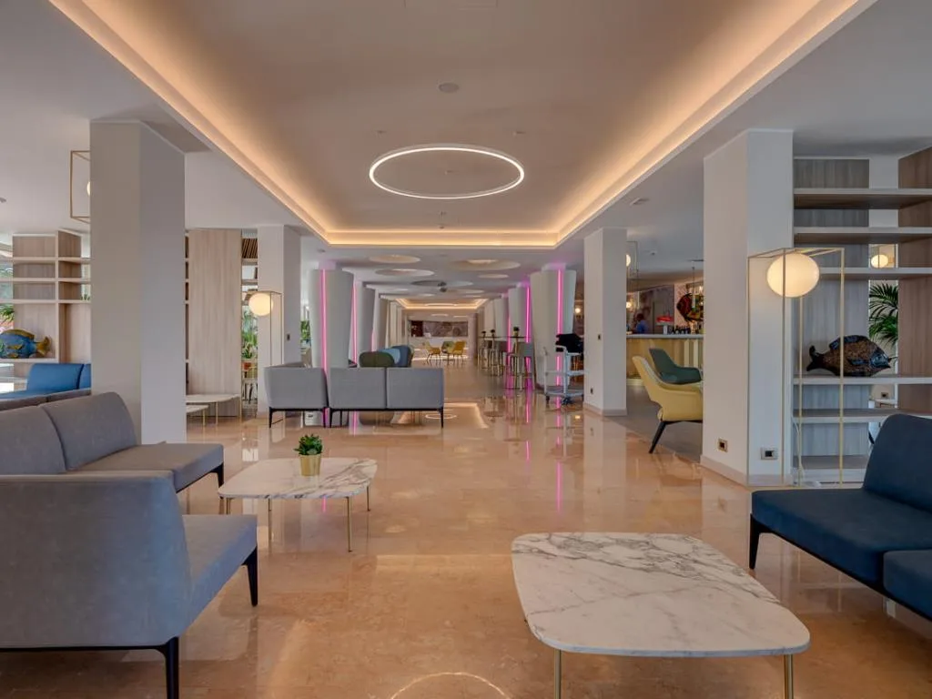 Ampia hall moderna con divani, tavolini in marmo e illuminazione decorativa