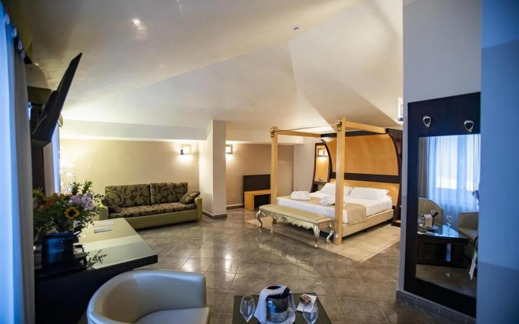 Suite ampia con letto a baldacchino, divano e zona soggiorno elegante