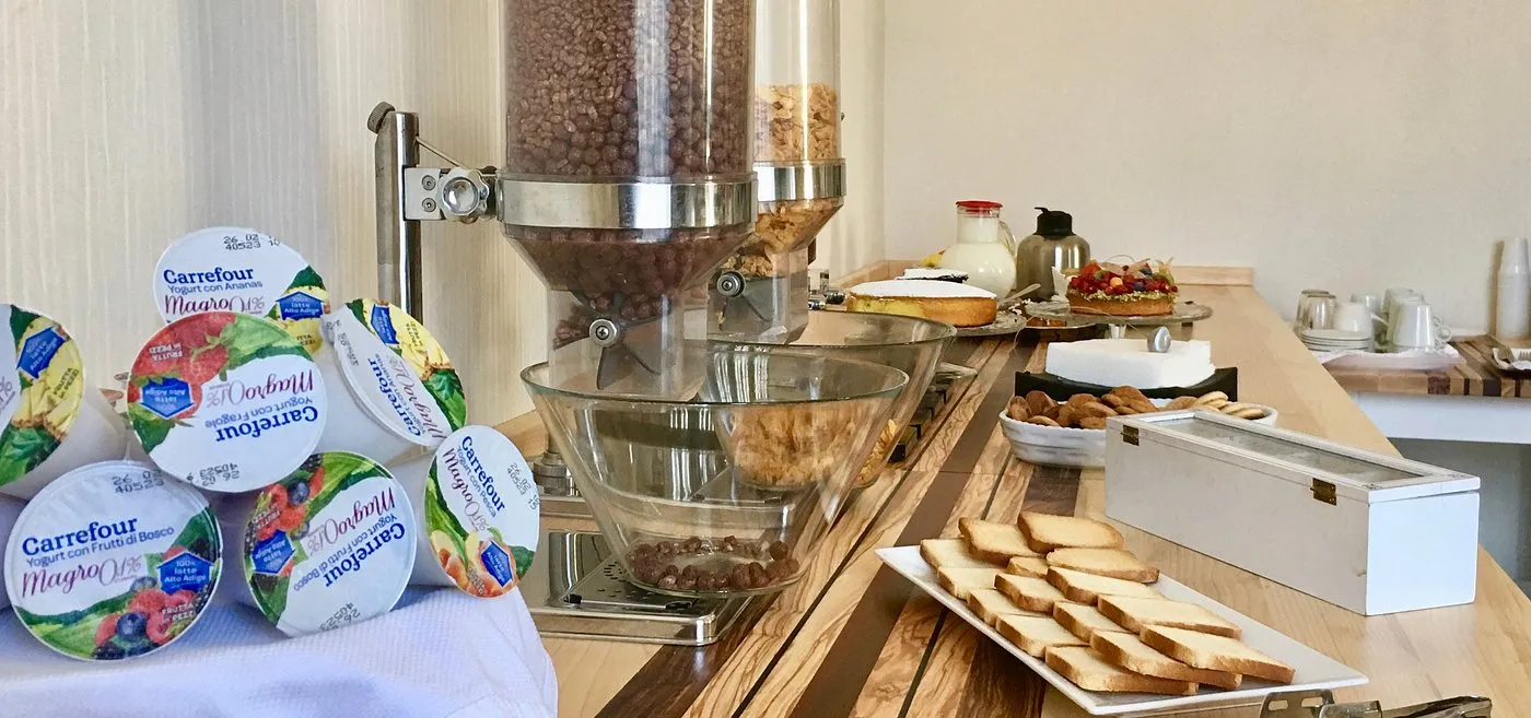 Buffet della colazione con cereali, yogurt, torte e biscotti su bancone in legno