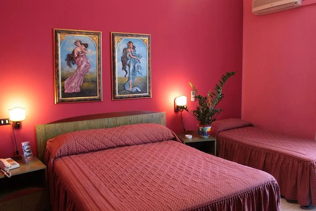 Camera tripla con pareti rosse, letto matrimoniale e singolo, quadri decorativi e pianta
