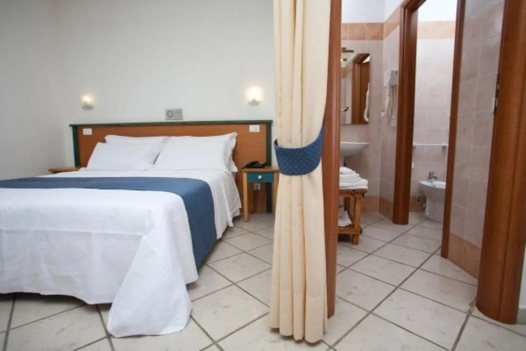 Camera matrimoniale con bagno privato e piastrelle chiare