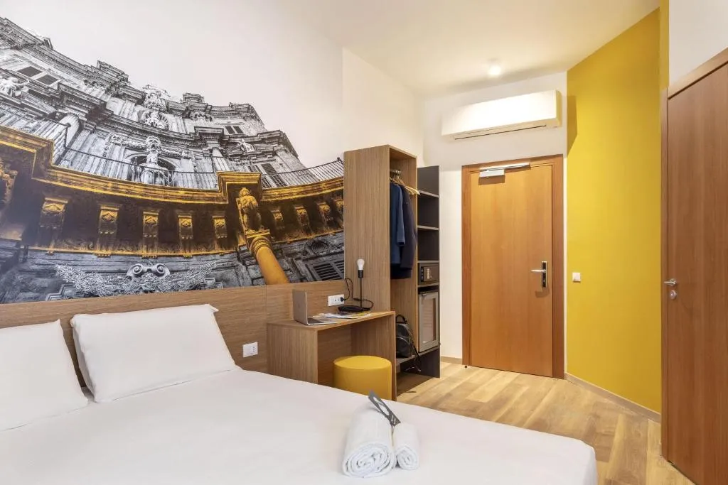 Camera con letto matrimoniale, armadio aperto e parete decorata con monumento