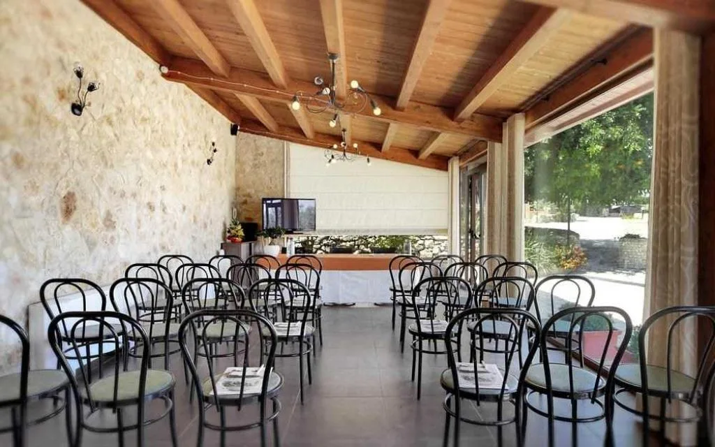 Sala meeting con sedie in ferro disposte a file e soffitto in legno