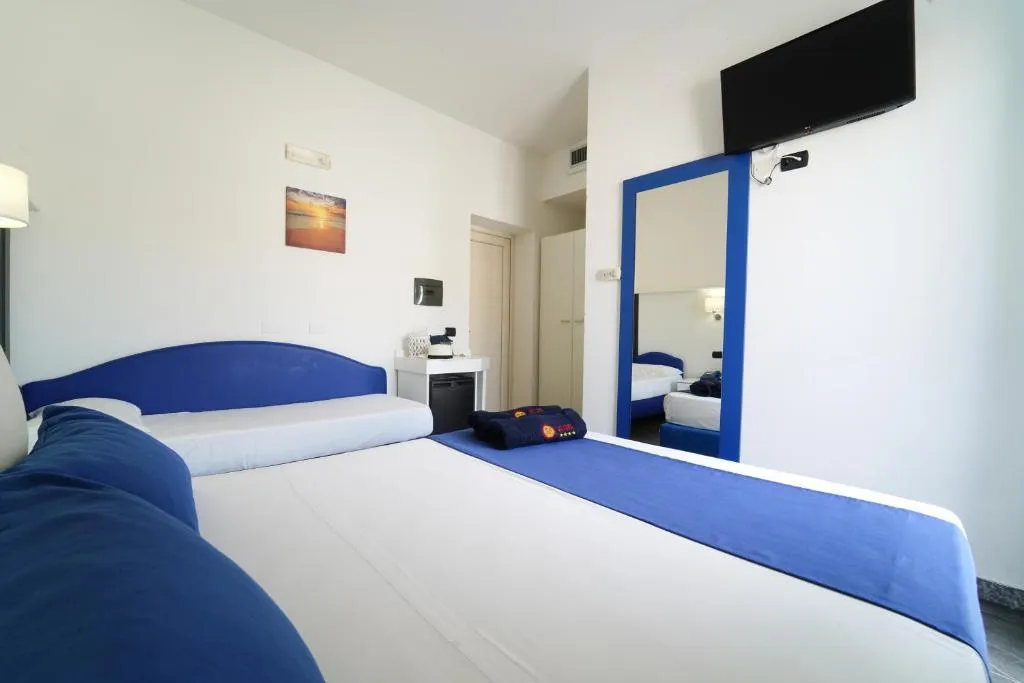 Camera con letto matrimoniale, dettagli blu, TV e specchio