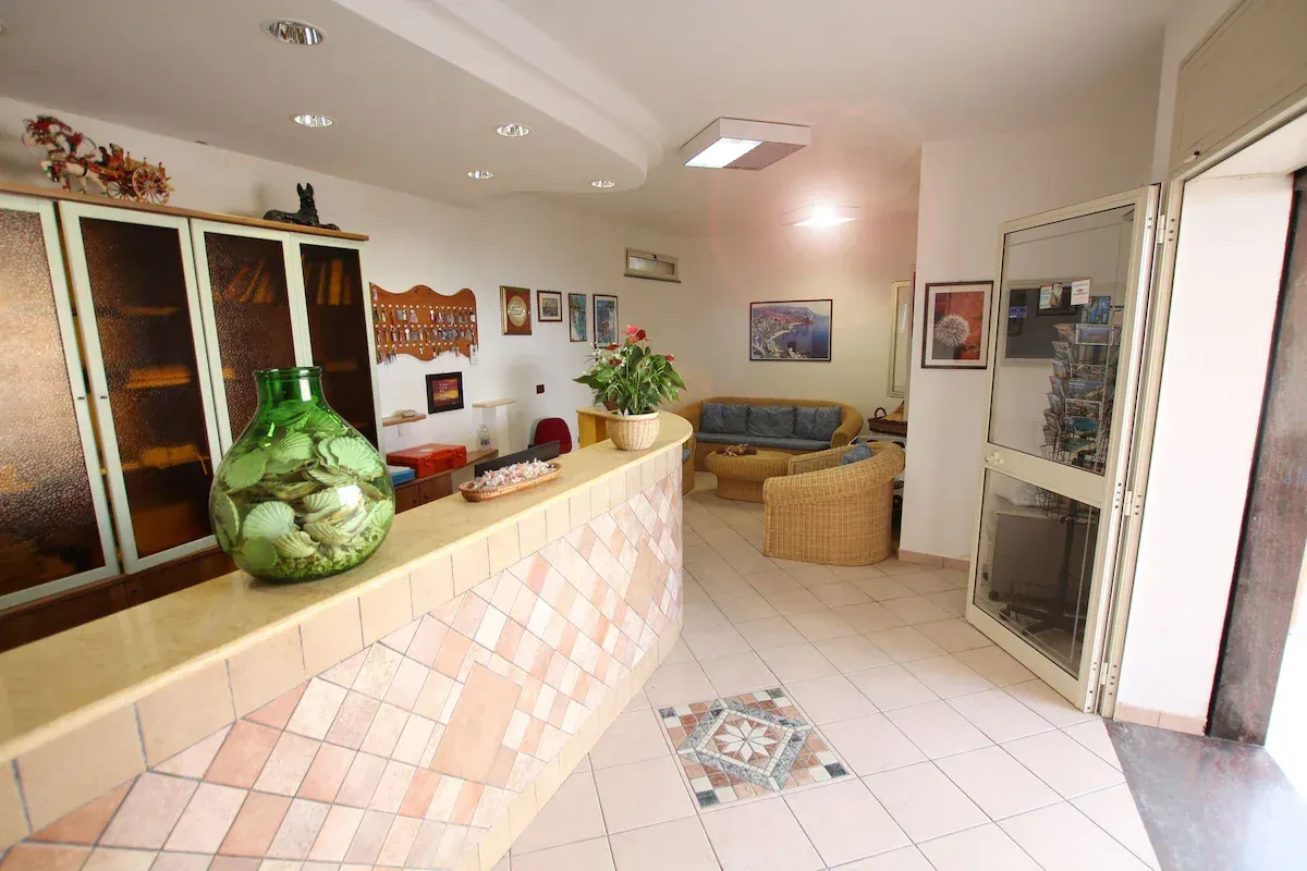 Hall della struttura con reception piastrellata e zona salotto