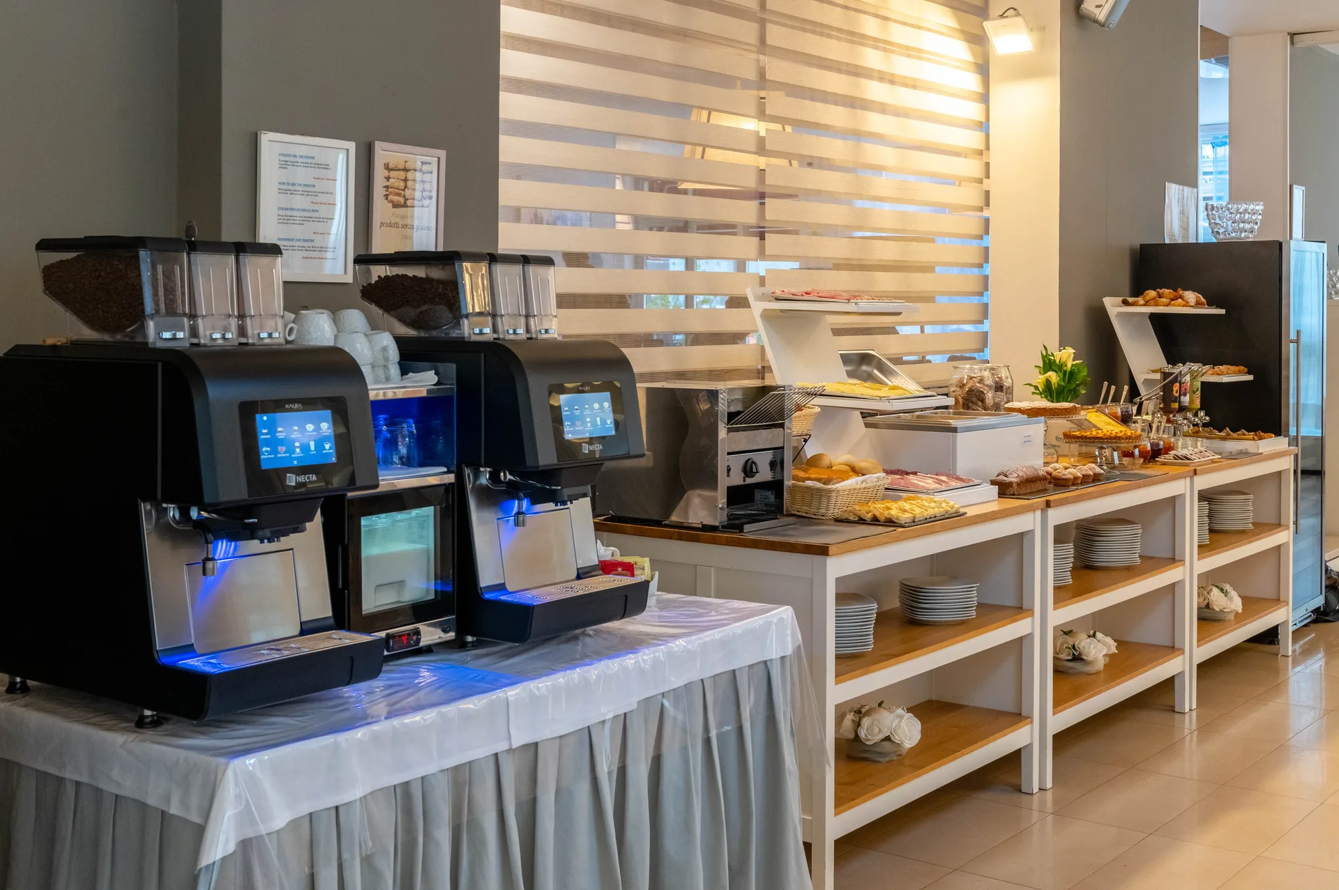 Buffet della colazione con macchine per caffè, cornetti e prodotti da forno