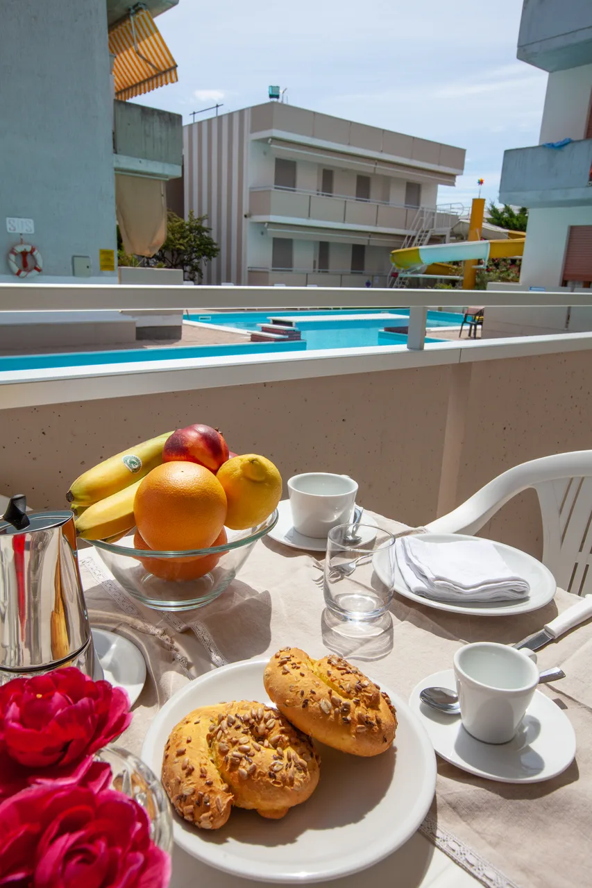 Colazione servita sul balcone con vista sulla piscina e lo scivolo
