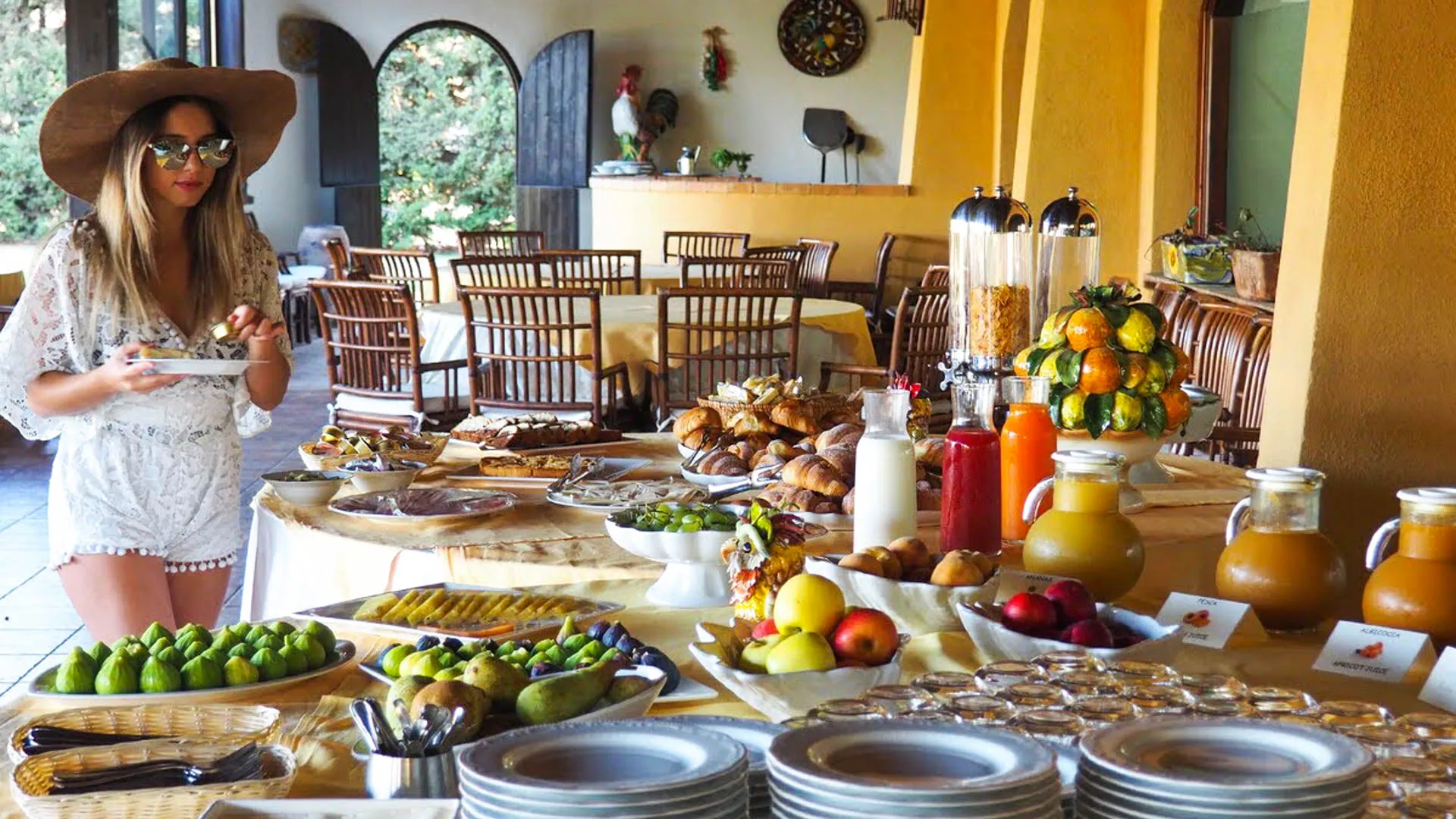 Buffet della colazione ricco di frutta fresca, succhi, dolci e pane con ospite