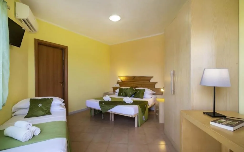 Camera tripla con letto matrimoniale e letto singolo, pareti gialle e aria condizionata
