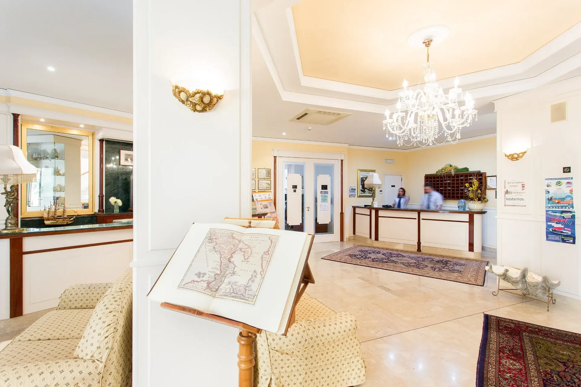Reception dell'hotel con lampadario, mappa antica e arredi eleganti