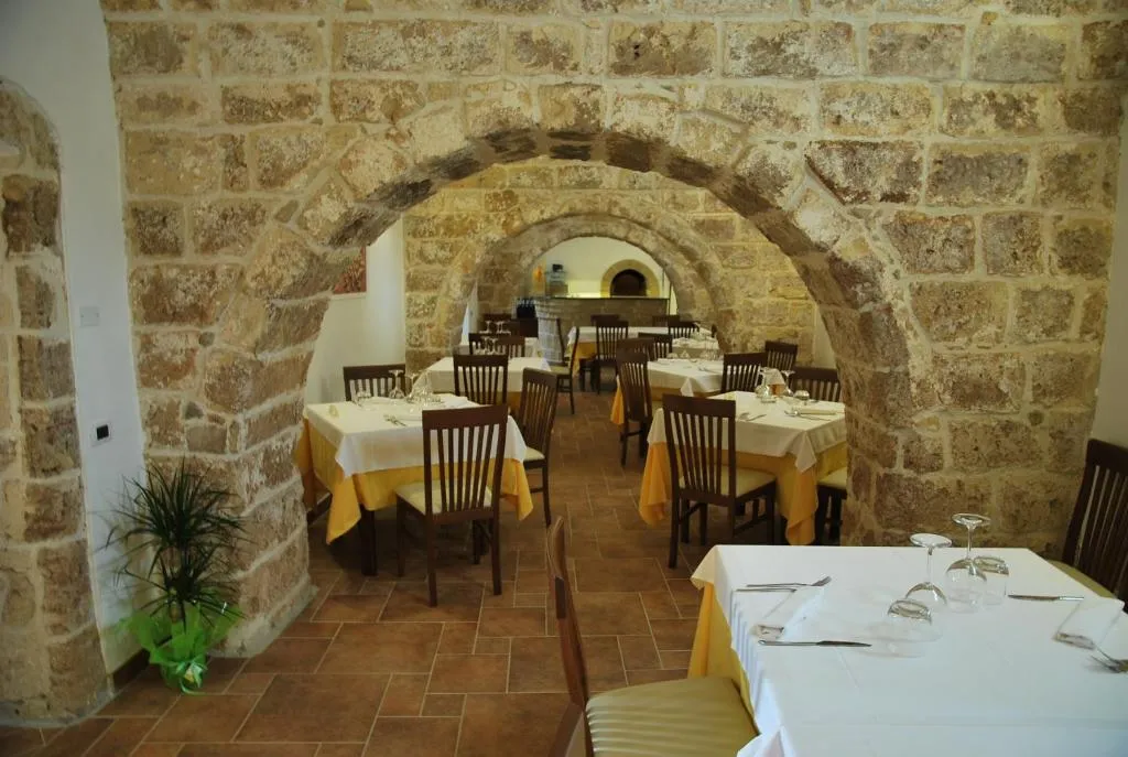 Sala ristorante con volte in pietra ad arco e tavoli apparecchiati