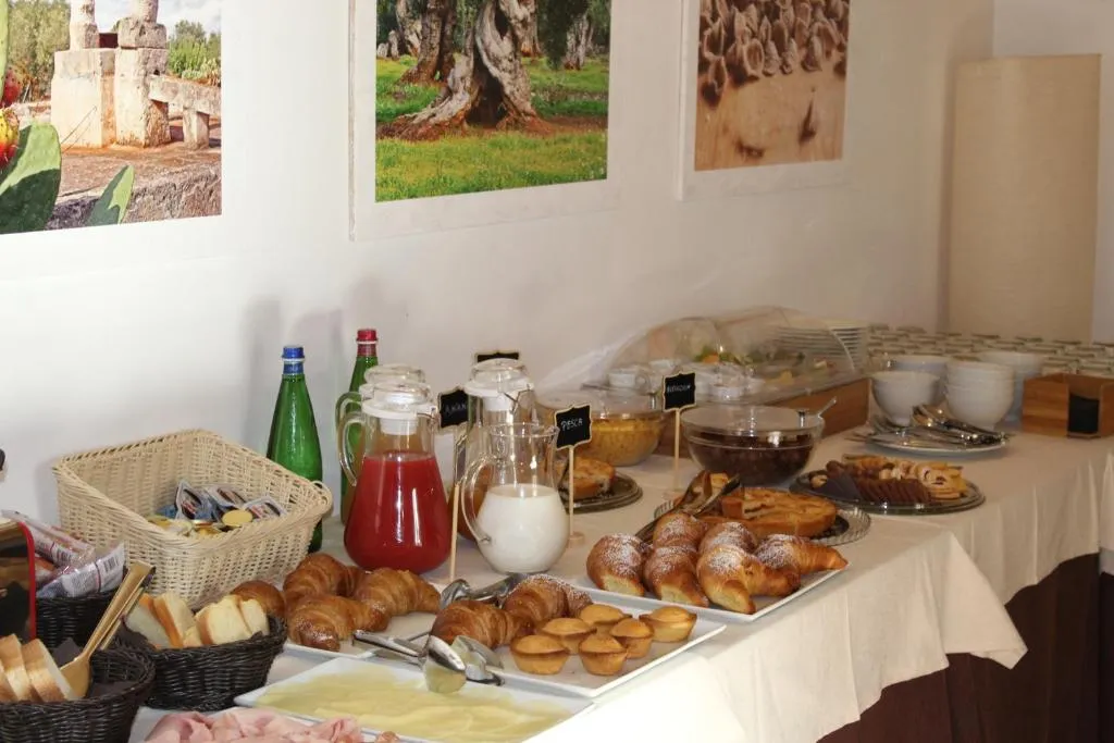 Buffet della colazione con cornetti, torte e succhi su tavolo apparecchiato