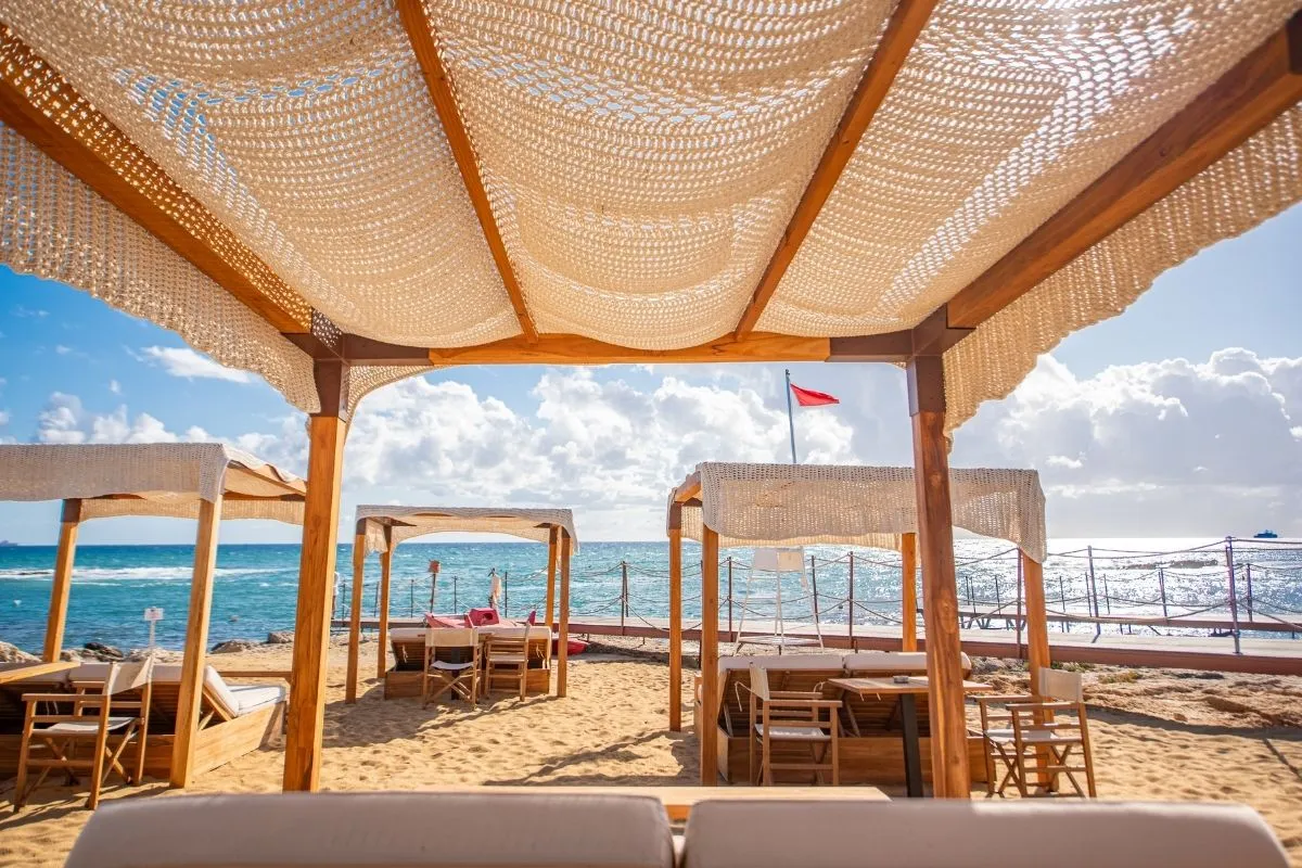 Gazebo in legno con tende sulla spiaggia vista mare e bandiera rossa