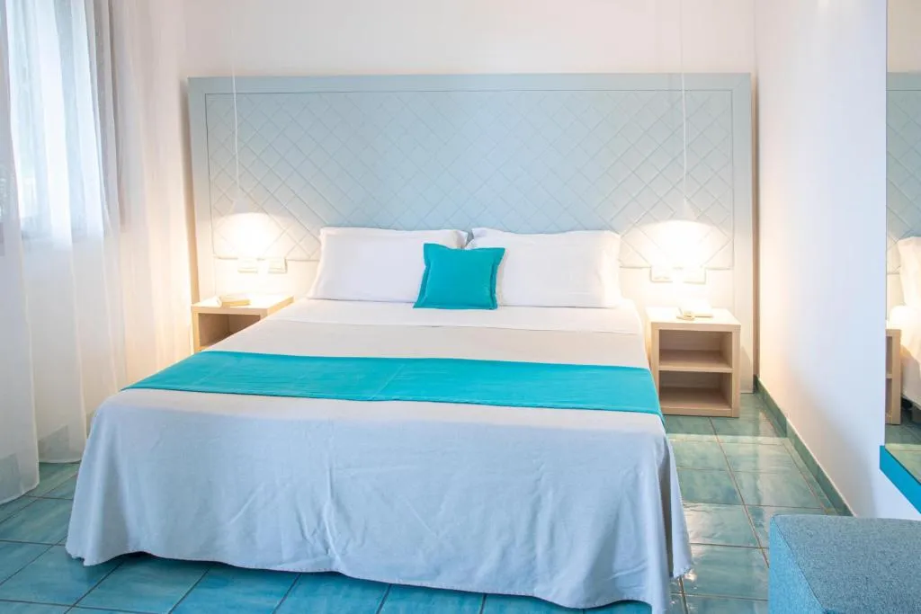 Camera da letto con testiera azzurra, cuscino turchese e pavimento in maiolica