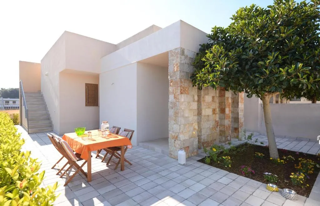 Patio esterno della villa con tavolo da pranzo e albero