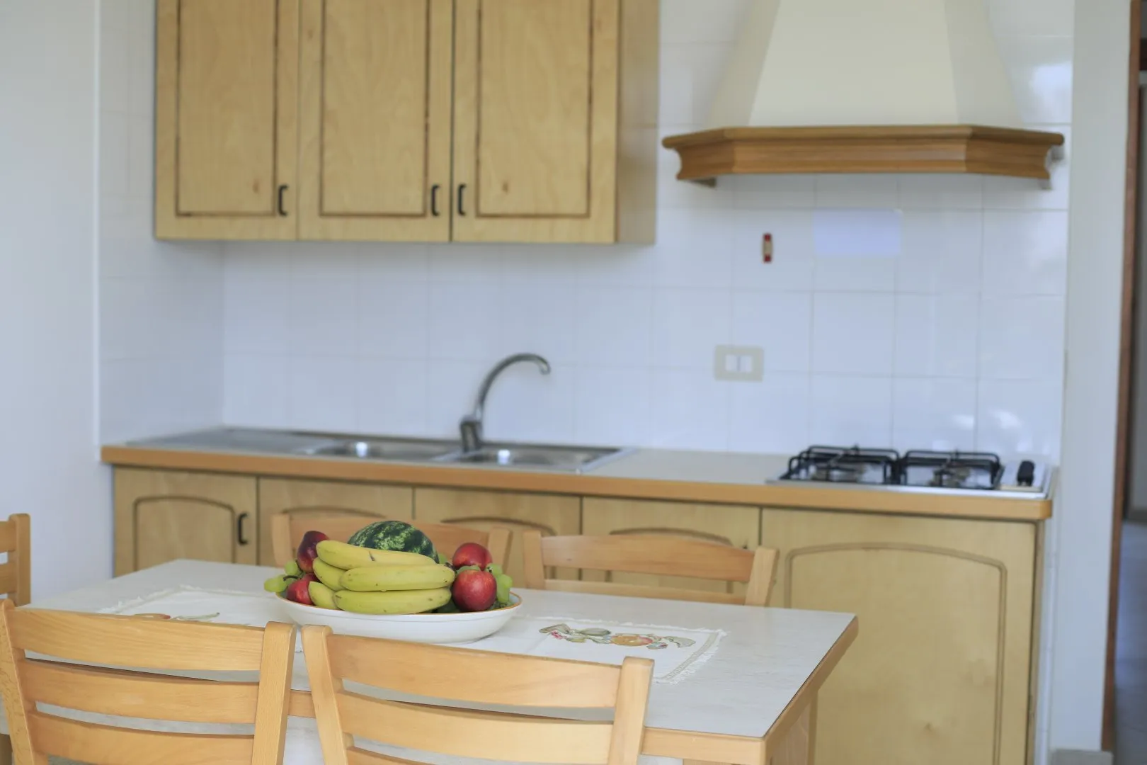 Cucina dell'appartamento con mobili in legno e tavolo da pranzo