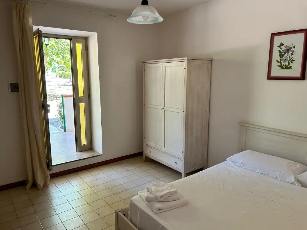 Camera da letto con armadio bianco e porta finestra che dà sull'esterno