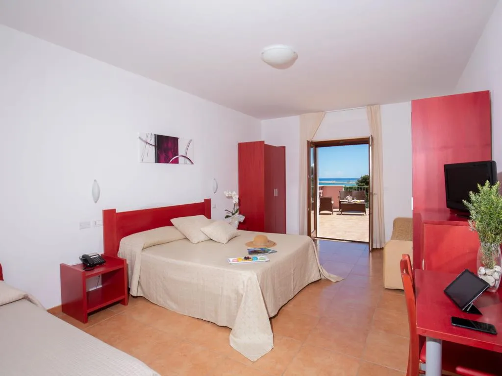 Spaziosa camera con arredi rossi e accesso alla terrazza con vista mare