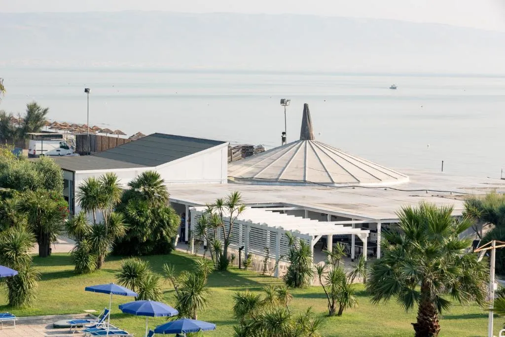 Struttura del resort con grande tettoia affacciata sul mare e palme