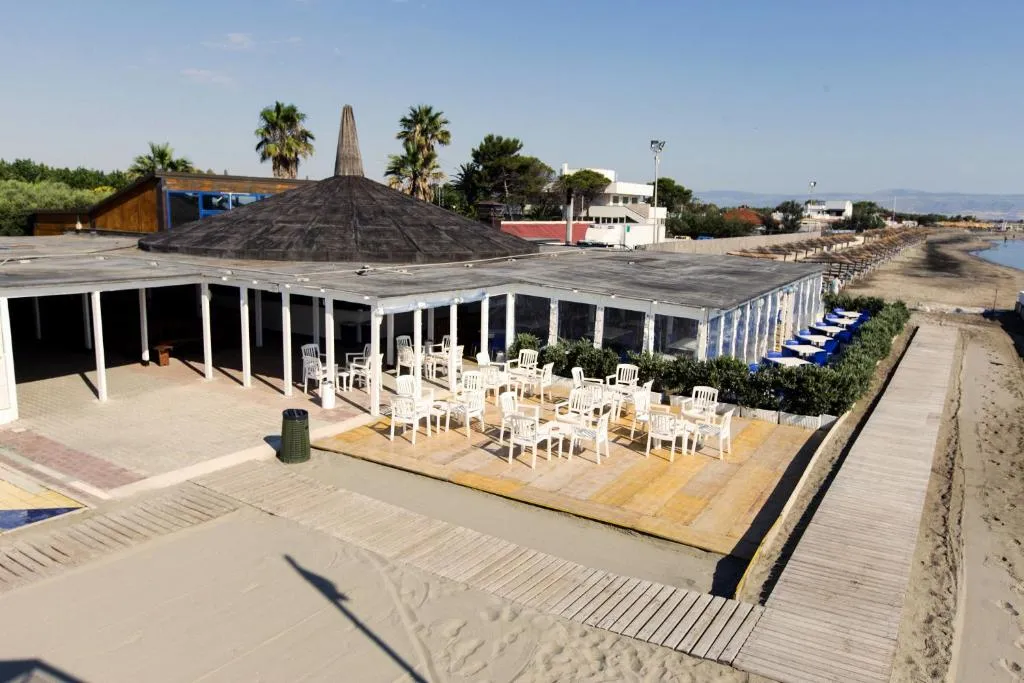 Area lounge con tavoli e sedie bianche sulla spiaggia accanto al mare