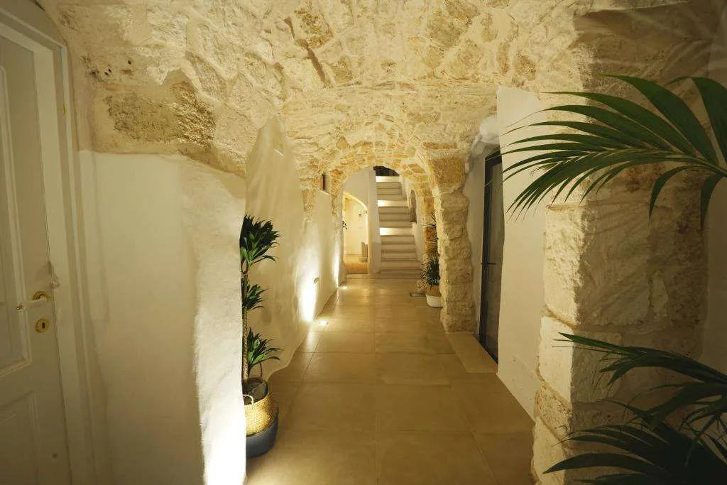 Corridoio interno con soffitto a volta in pietra e piante verdi