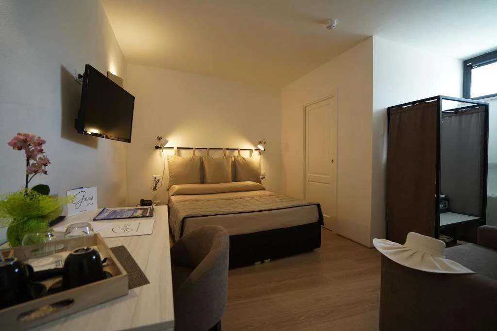 Camera con letto matrimoniale, TV, scrivania e angolo relax