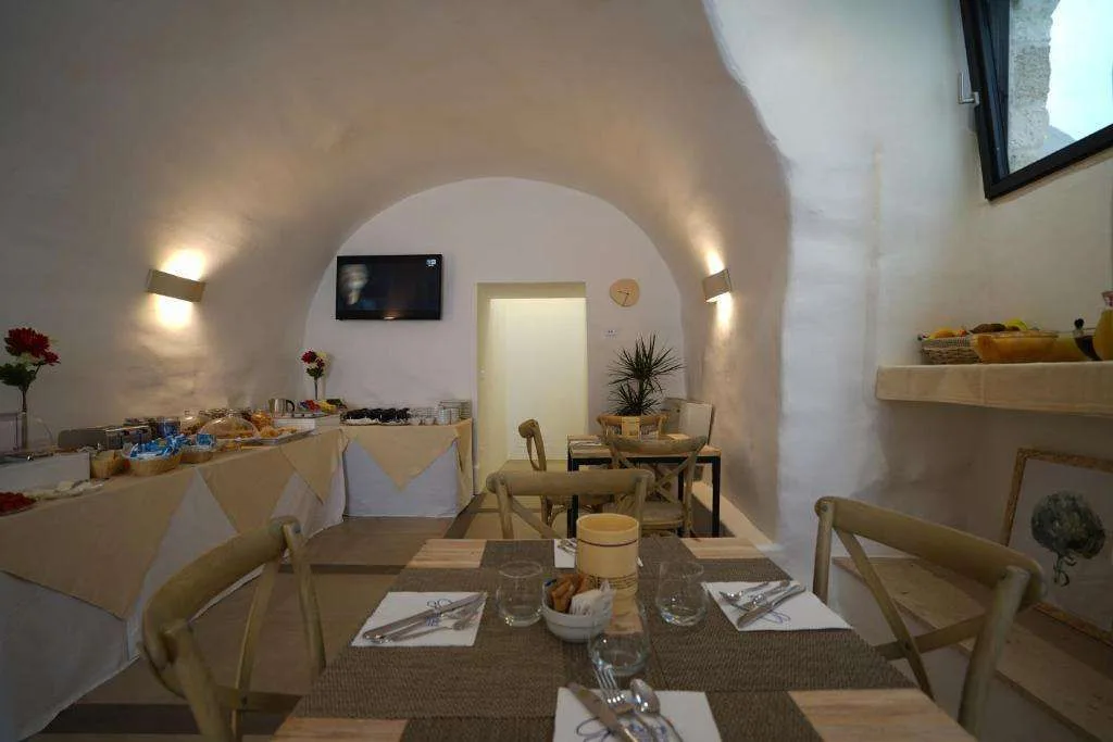 Sala colazione con tavoli apparecchiati e soffitto a volta in pietra