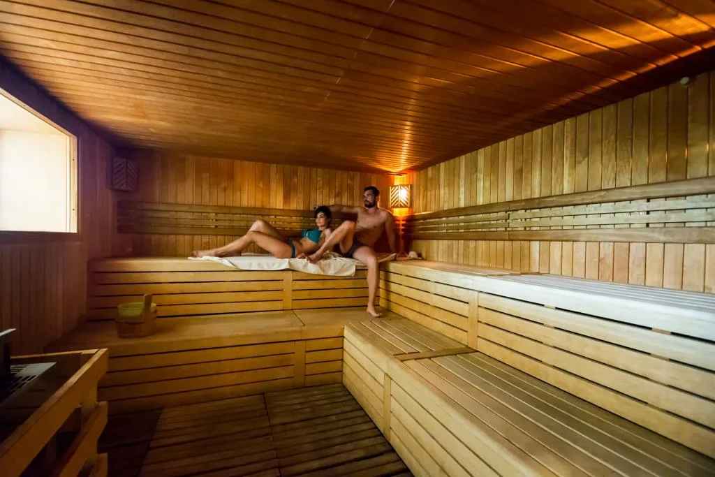 Sauna finlandese in legno con coppia che si rilassa