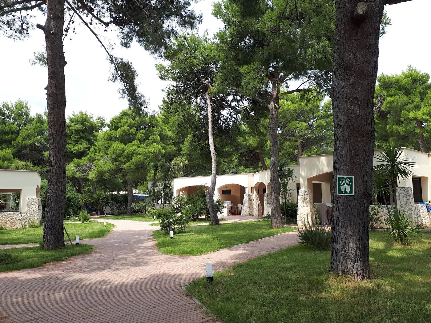 Bungalow immersi nel verde tra pini e vialetti in mattoni del villaggio