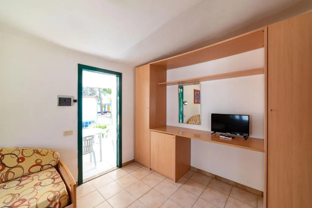 Soggiorno con armadio in legno, TV e accesso alla veranda