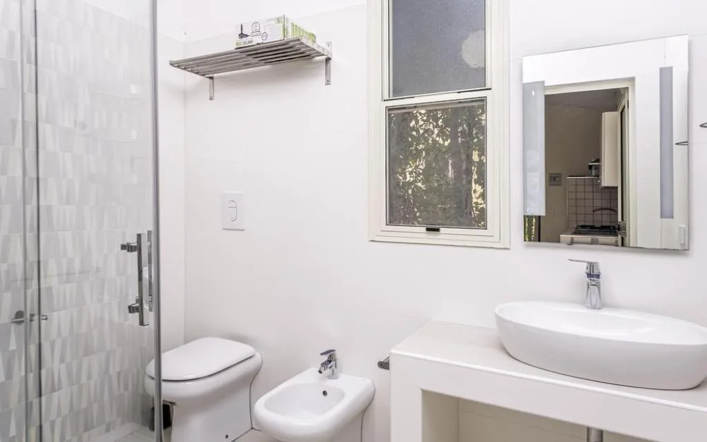 Bagno moderno con doccia, WC, bidet, lavabo e specchio