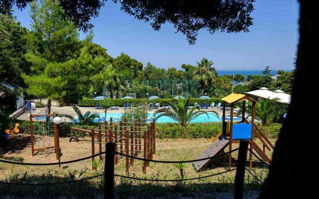 Vista sulla piscina e area giochi per bambini con mare sullo sfondo