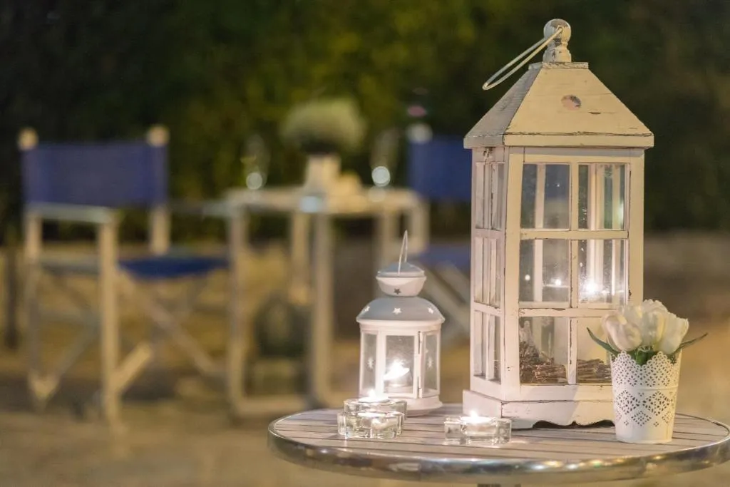 Lanterne decorative e candele su tavolino in giardino