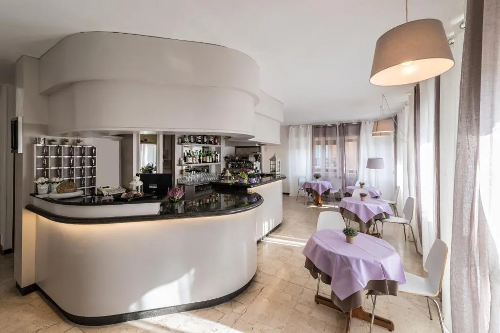 Bar interno con bancone curvo e sala colazione luminosa