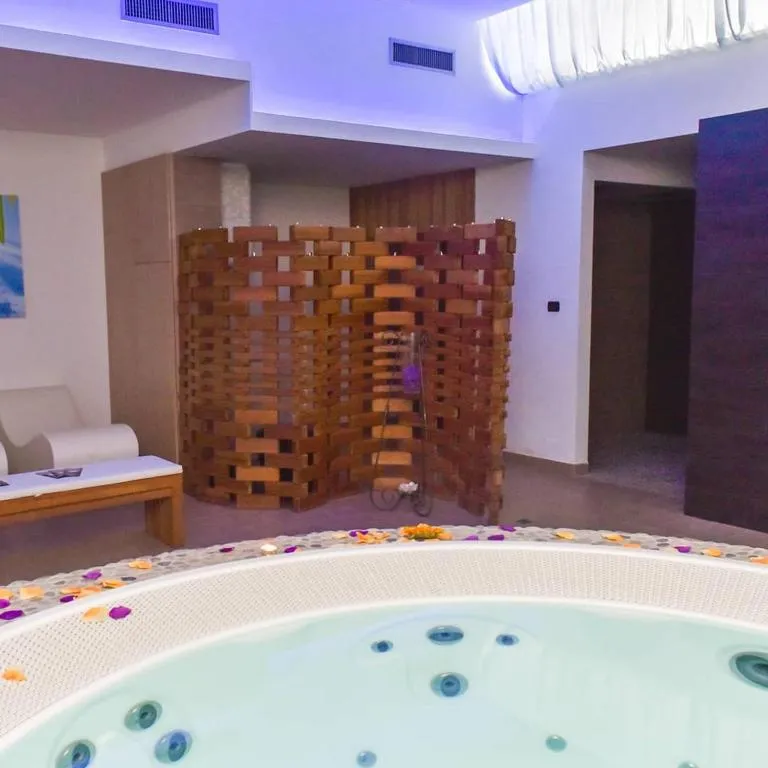 Area benessere con vasca idromassaggio decorata con petali di fiori