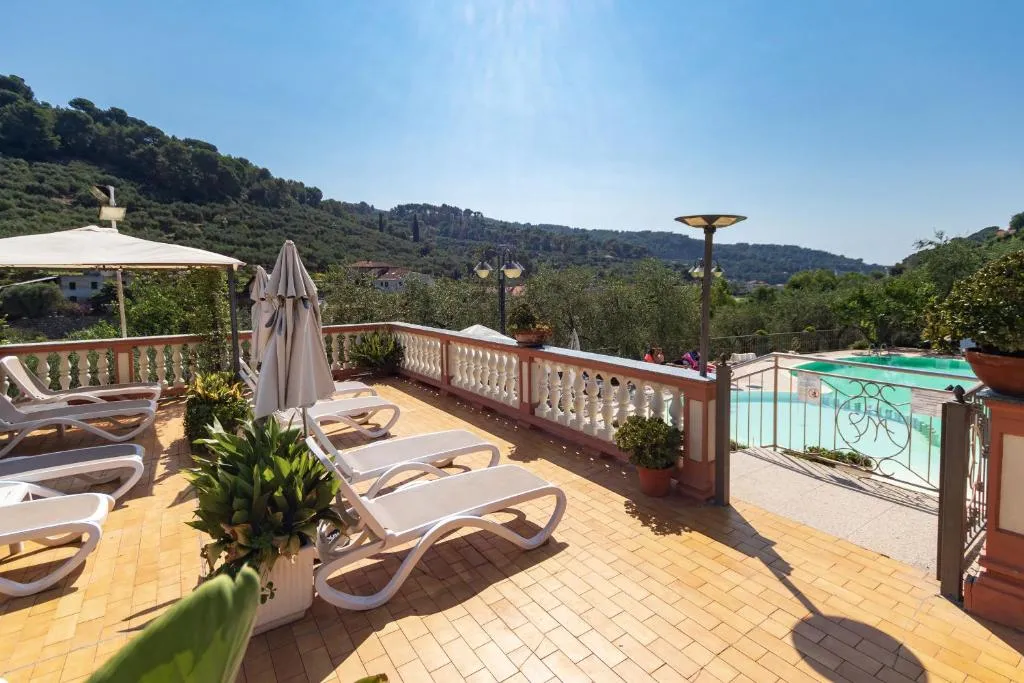 Terrazza solarium con lettini e ombrelloni vista colline e piscina