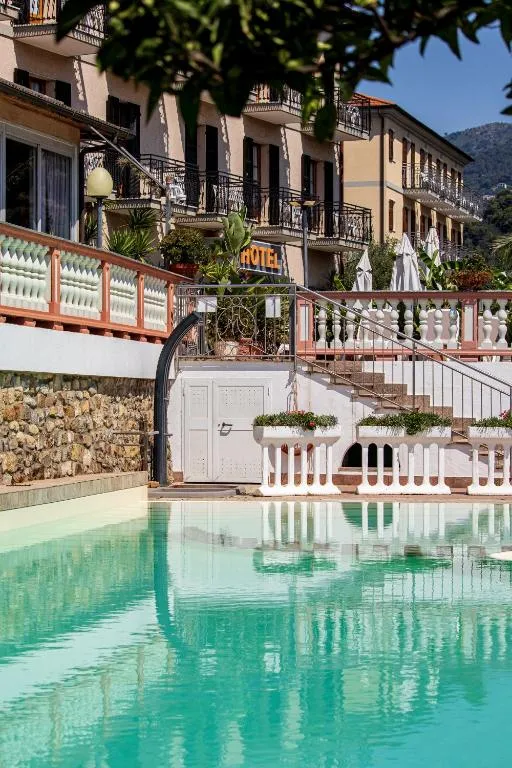 Piscina con acqua turchese e vista sulla facciata dell'hotel