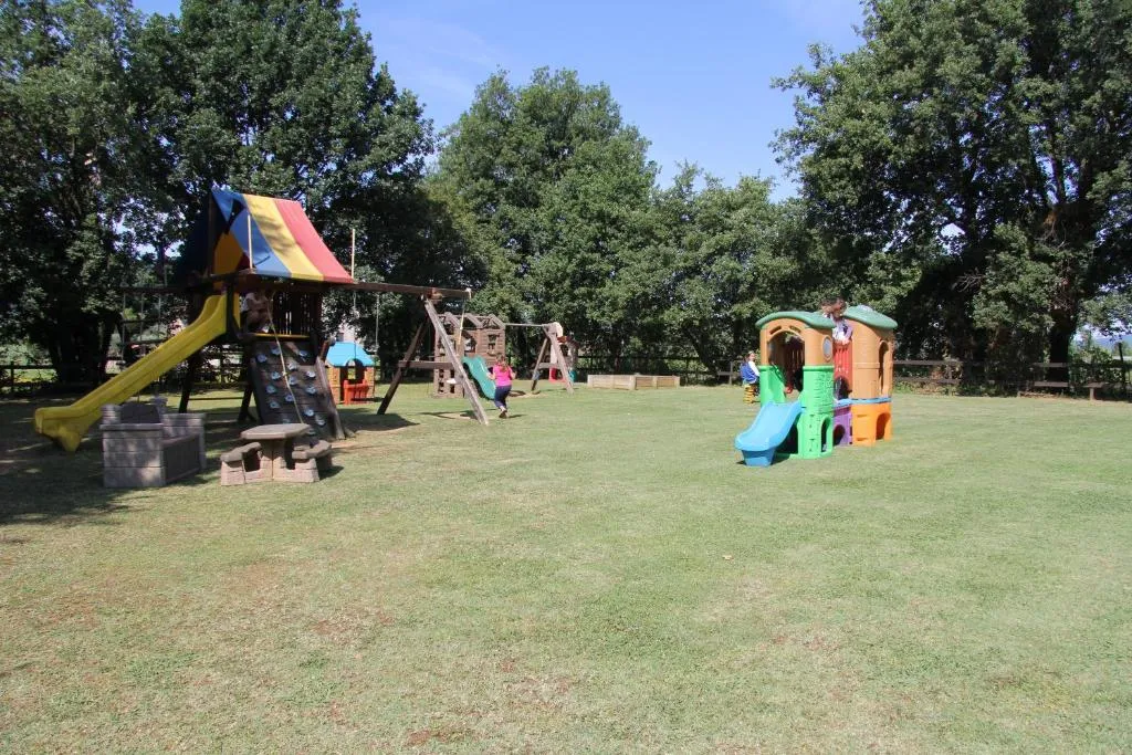 Area giochi per bambini con scivoli e casette nel prato verde