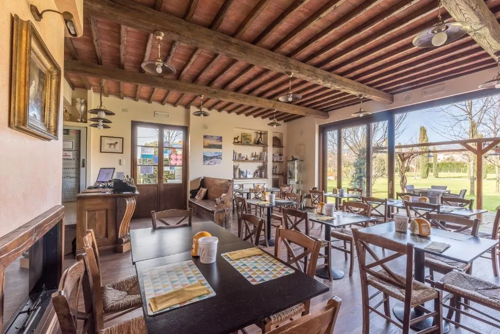 Sala ristorante rustica con travi a vista e ampie vetrate sul giardino